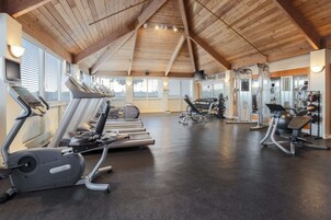 Un gimnasio con cintas de correr, elípticas y equipos de pesas.