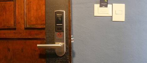 A hotel room door with a digital lock, a keyhole, and a card reader.