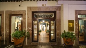 The entrance to Hotel Casino Morielia, featuring a stone facade, arched doorway, and potted plants.