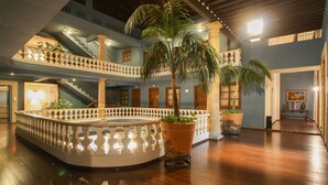 A spacious atrium with a central fountain, multiple floors, and a staircase.