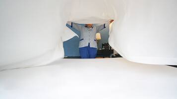 A person in a room with a blue wall and a lamp.