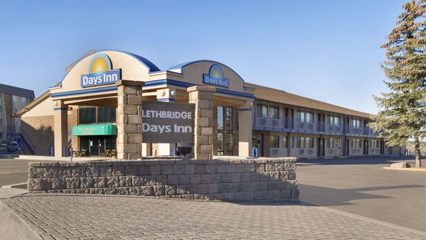 A Days Inn building with a prominent sign, a brick entrance, and a paved area in front.