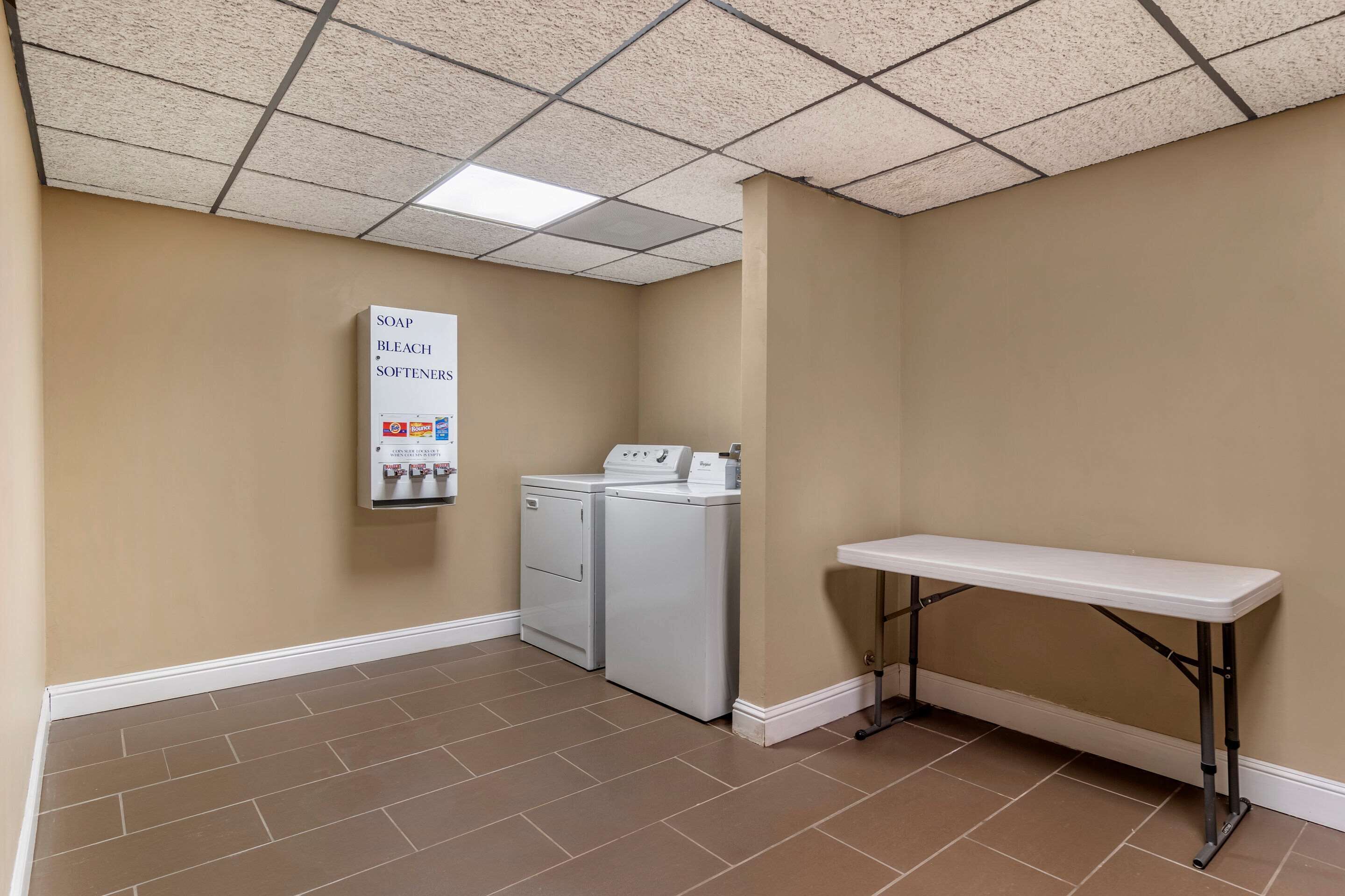 A laundry room with a washing machine, dryer, and a bench.