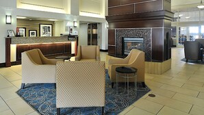 A lobby with a reception desk, seating area, and a fireplace. - Hampton Inn & Suites by Hilton Calgary-Airport (Calgary)