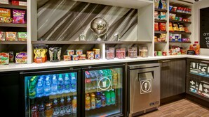 A snack bar with a variety of snacks and drinks, including a globe decoration and a welcome sign. - Hampton Inn & Suites by Hilton Calgary-Airport (Calgary)