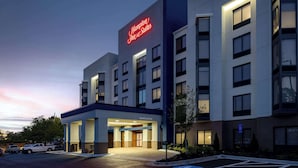 A modern hotel building with a prominent neon sign for Hampton Inn & Suites. - Hampton Inn & Suites Alpharetta Roswell (Alpharetta)