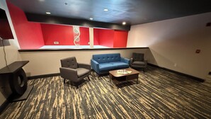 A room with a blue sofa, two armchairs, a coffee table, and a carpeted floor. - Ramada by Wyndham Albany GA (Albany)
