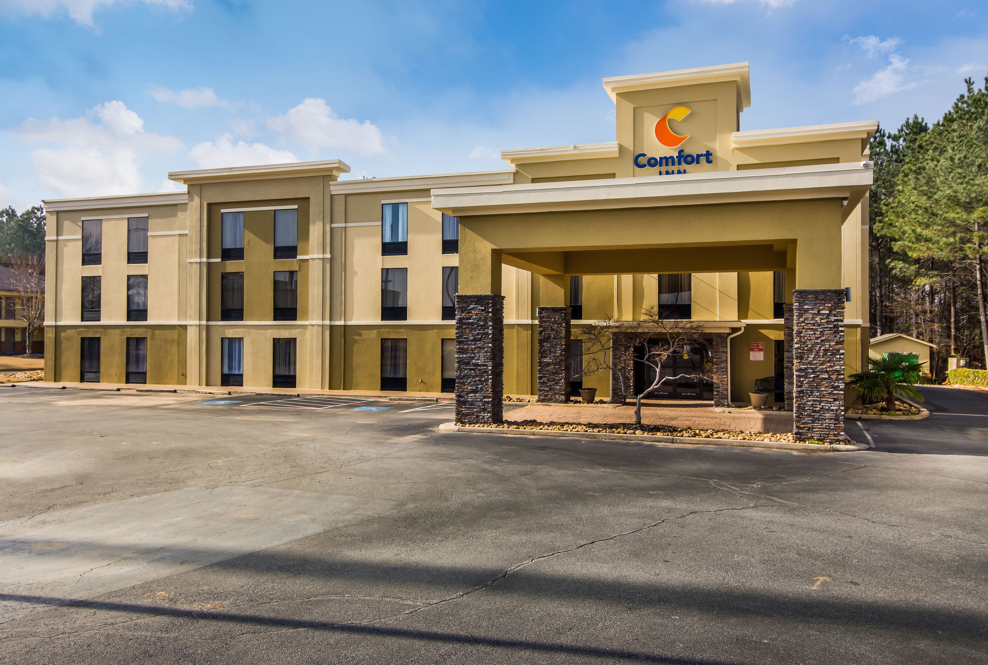 Um hotel Comfort Inn com estrutura de dois andares, entrada coberta e estacionamento.