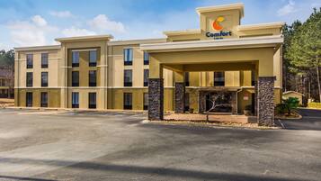 Um hotel Comfort Inn com estrutura de dois andares, entrada coberta e estacionamento.