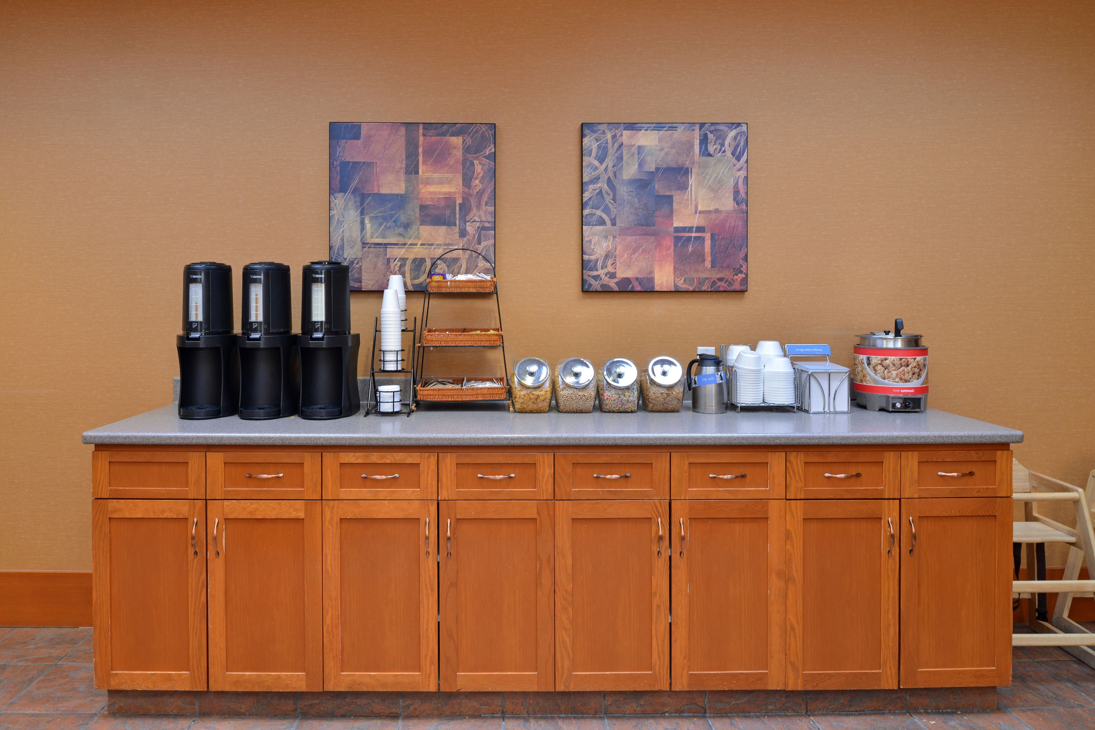 A kitchen counter with coffee makers, a coffee pot, and various containers.