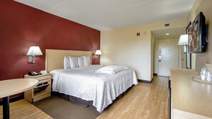 Une chambre d’hôtel comprenant un lit, des tables de chevet, un bureau et un téléviseur.
