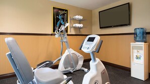 A fitness area with an elliptical machine, a stationary bike, and a water dispenser.