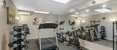 A gym with exercise equipment, a treadmill, and a stationary bike.