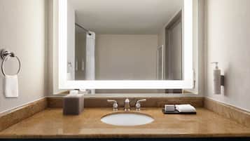 Un bagno con un ampio specchio, un lavandino e un portasciugamani.