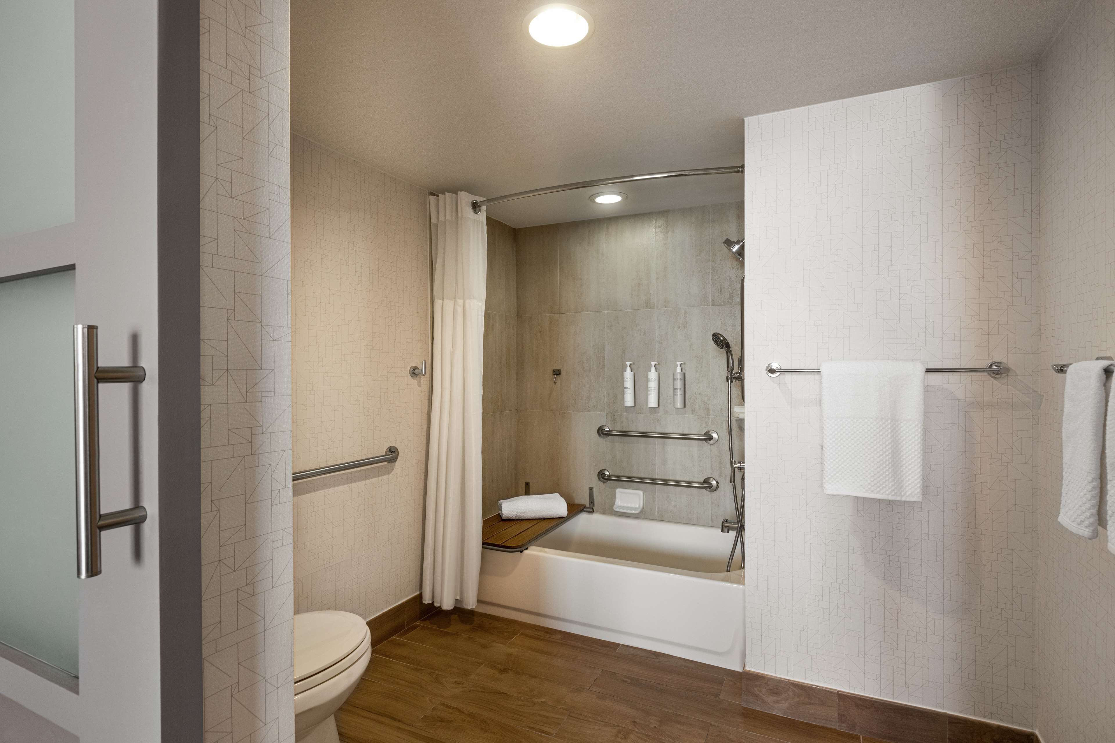 A modern bathroom with a shower, toilet, and bathtub.