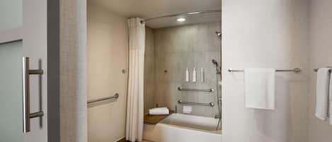 A modern bathroom with a shower, toilet, and bathtub.