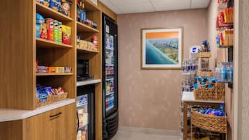 A snack and beverage section with shelves stocked with chips, candies, and a refrigerated drink cooler.