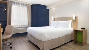 A modern hotel room with a bed, a desk, and a chair. - Spark by Hilton Brockville (Brockville)