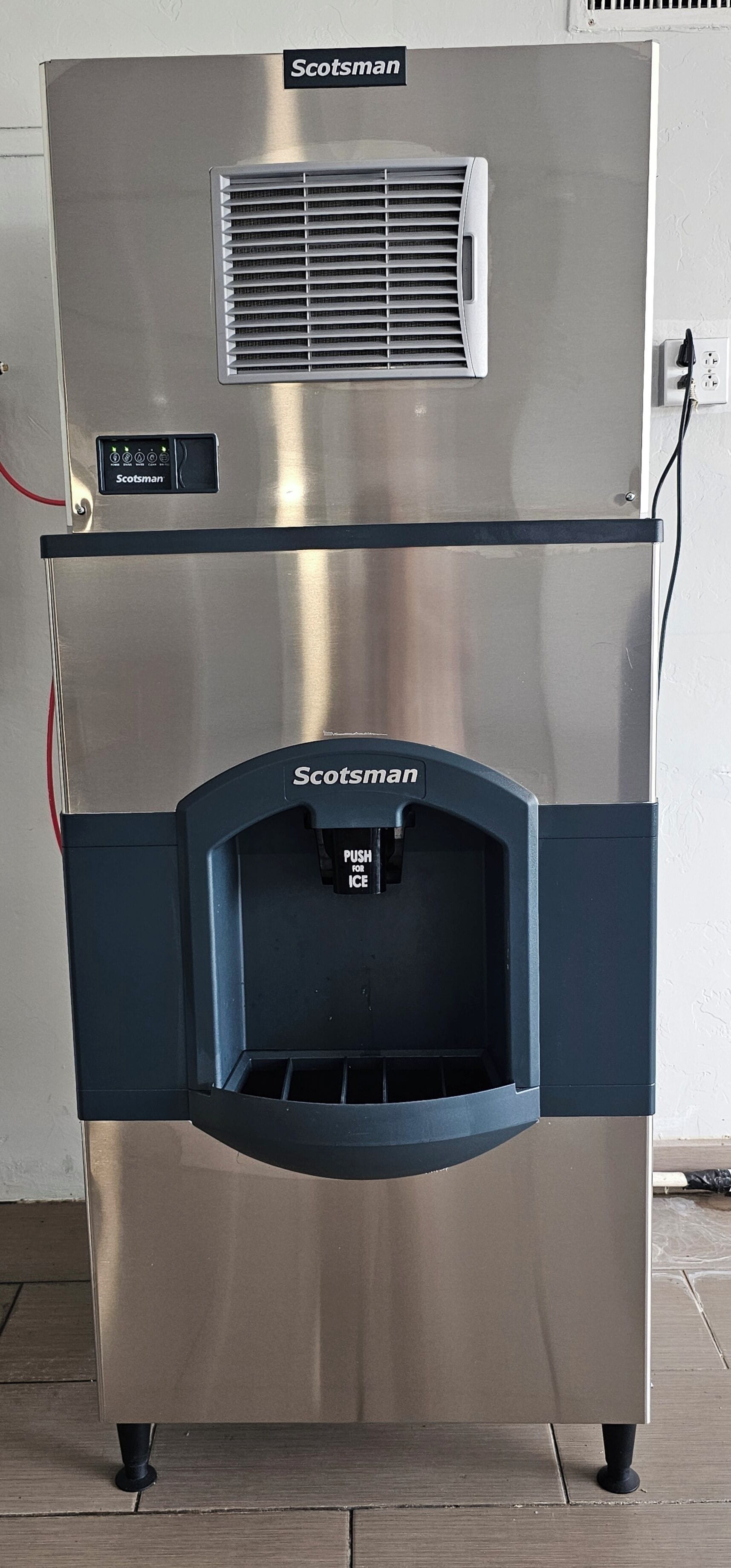 Een ijsmachine van Scotsman, van roestvrij staal, met bedieningspaneel en een knop voor ijs.
