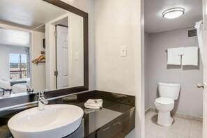 A modern bathroom with a large mirror, a white sink, and a toilet. - Motel 6 Tucson, AZ (Tucson)