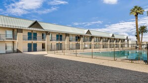 A motel with a swimming pool, multiple balconies, and a gravel courtyard. - Motel 6 Tucson, AZ (Tucson)