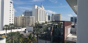 A high-rise building with multiple floors and balconies, surrounded by palm trees and other buildings. - Albion South Beach Hotel (Miami Beach)