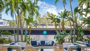 A poolside area with lounge chairs, a sofa, and a coffee table. - Albion South Beach Hotel (Miami Beach)