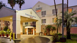 L’entrée d’un hôtel Fairfield Inn & Suites Marriott, avec une allée couverte, des palmiers et des plantes en pot.