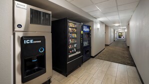 Ein Hotelkorridor mit Verkaufsautomaten, darunter ein Eisspender und eine Getränkeautomaten.