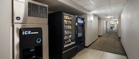 A hotel corridor with vending machines, including an ice dispenser and a cold drink machine.