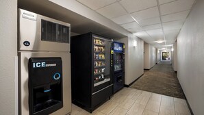 A hotel corridor with an ice dispenser, a vending machine, and a cold drink machine. - Red Roof Inn Tucson North - Marana (Tucson)