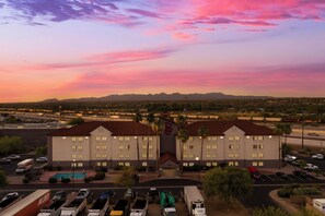A hotel with a parking lot, a swimming pool, and a view of mountains. - Red Roof Inn Tucson North - Marana (Tucson)
