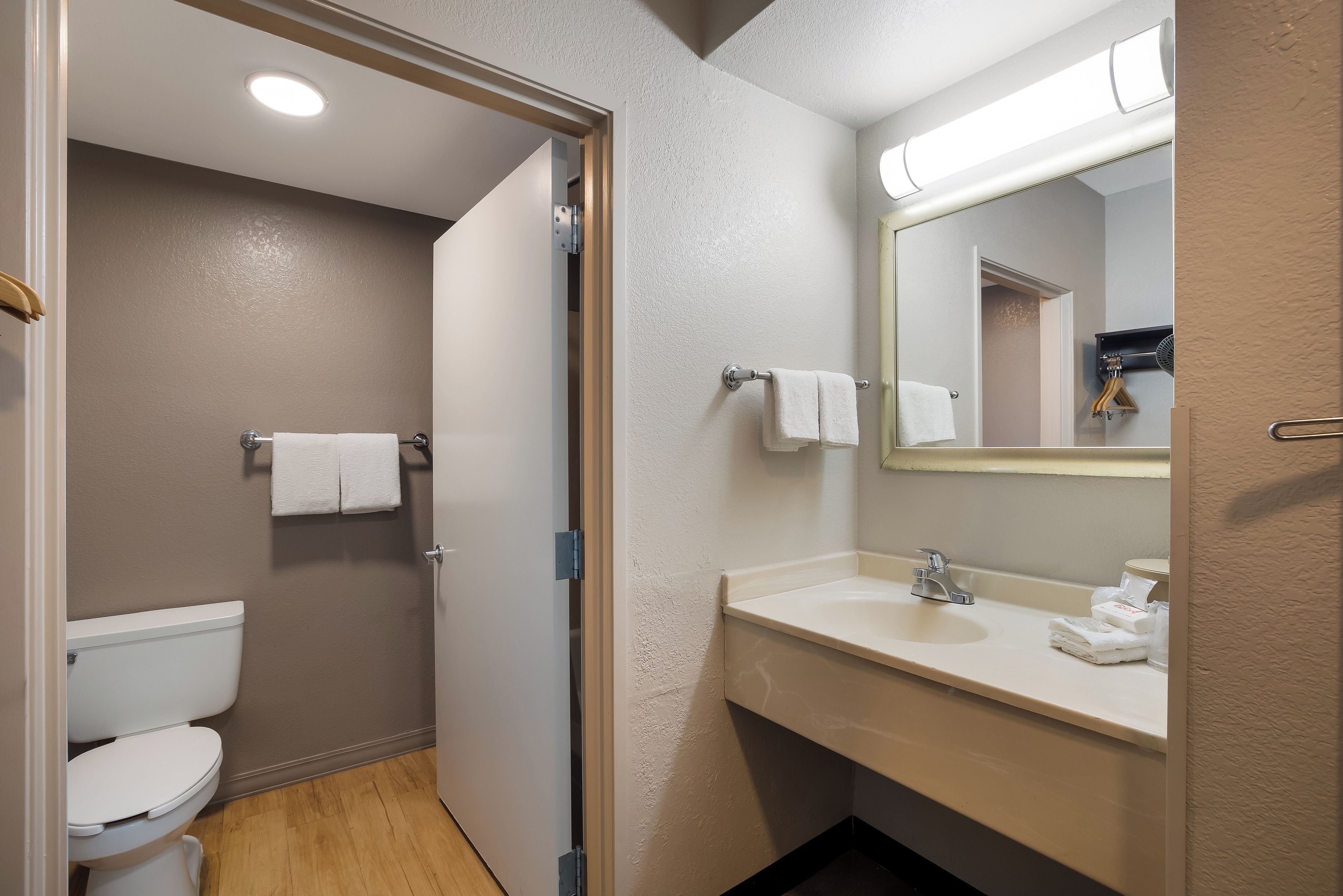 Une salle de bain équipée d’un WC, d’un lavabo, d’un miroir et d’un porte-serviettes.