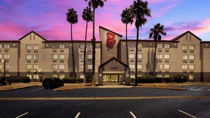 Ein Hotel mit flacher Fassade, zahlreichen Fenstern und einem Schild mit der Aufschrift 'Red Roof Inn'.