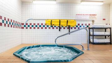 A spa area with a hot tub, a yellow safety rail, and a sign with instructions for spa users.