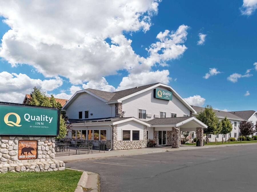 A Quality Inn by Choice Hotels with a stone facade and a clear blue sky.