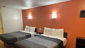 A hotel room with two beds, a wooden floor, and a red accent wall. - Beachside Inn Motel (Anaheim)