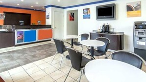 A modern hotel lobby with a reception desk, seating area, and ATM. - Beachside Inn Motel (Anaheim)