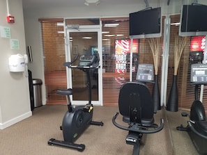 A gym with exercise equipment, a treadmill, and a stationary bike.