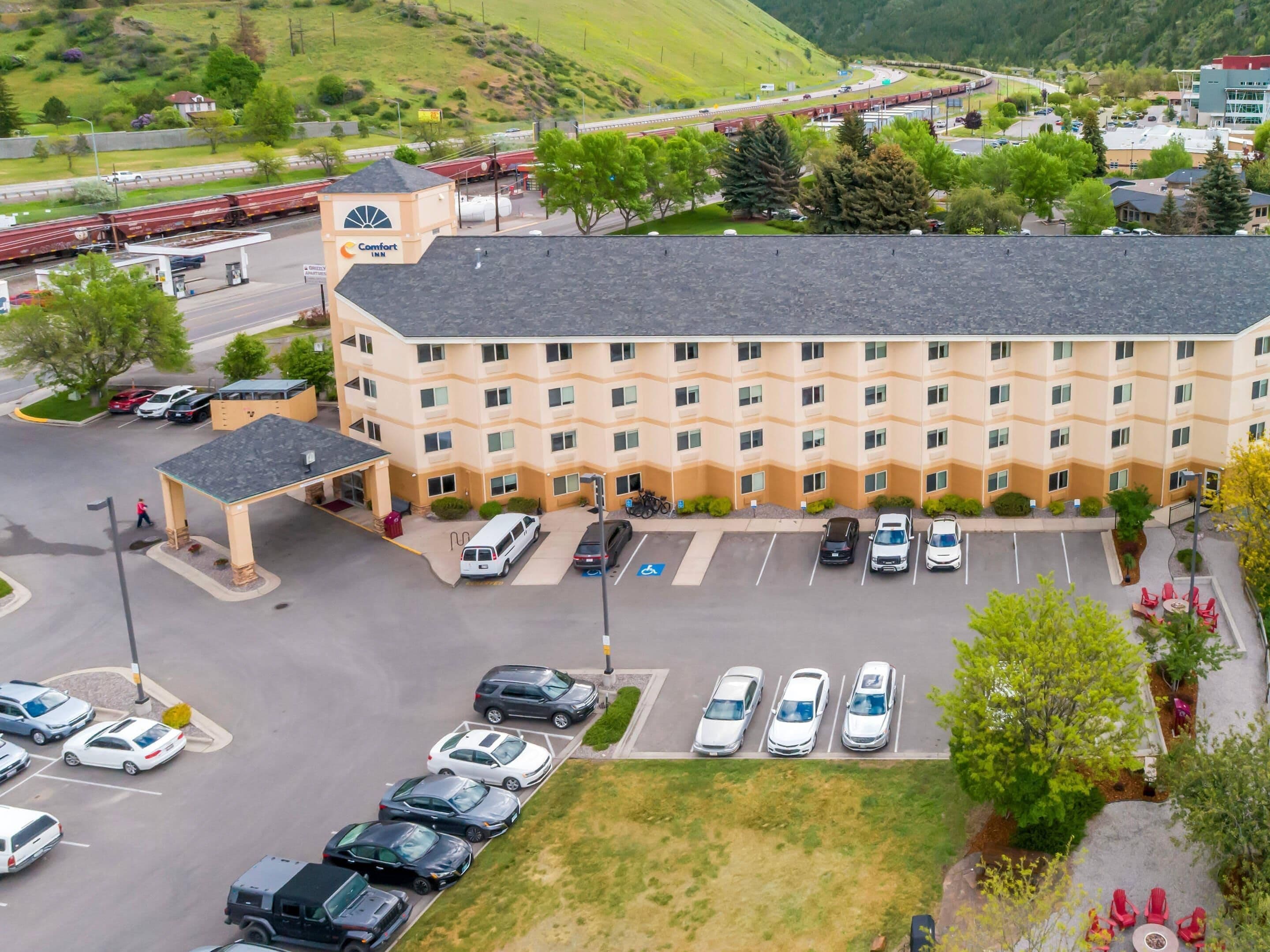 Un hôtel à plusieurs étages doté d’un parking, d’une zone abritée et offrant une vue sur une autoroute.