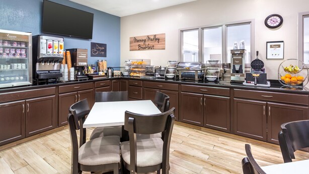 A breakfast area with a coffee machine, a TV, and a sign that reads "Morning Melly Breakfast." - Sleep Inn Missoula Southgate (Missoula)