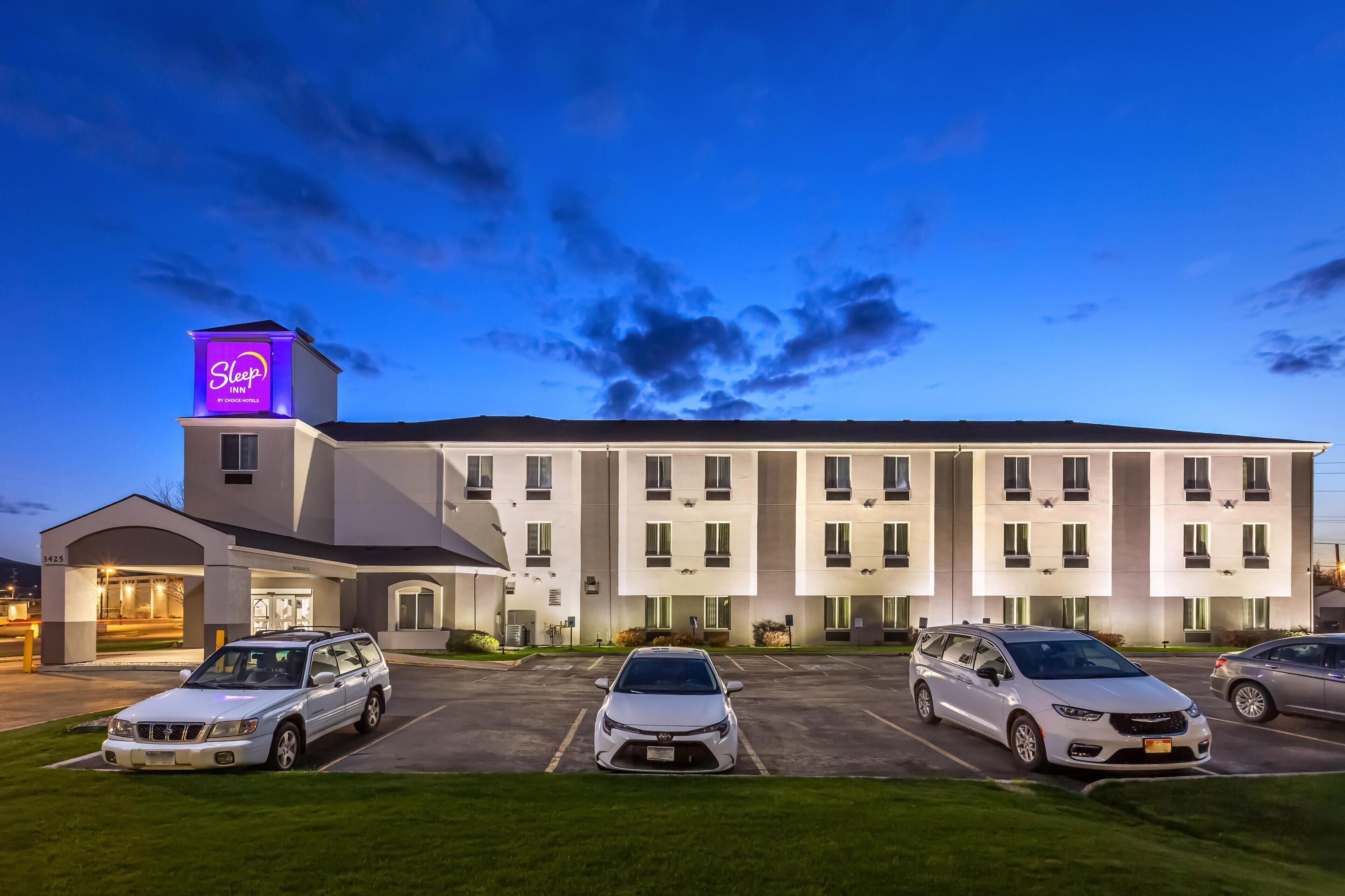 A Sleep Inn hotel with a parking lot and several cars parked.