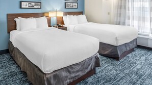 A hotel room with two beds, a nightstand, a lamp, and framed pictures on the wall. - Sleep Inn Missoula Southgate (Missoula)