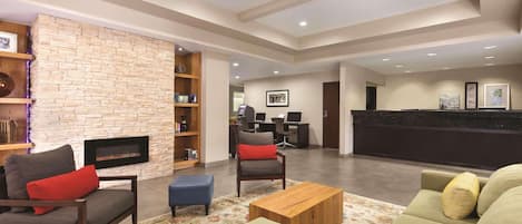 A modern lobby with a fireplace, seating area, and a reception desk.