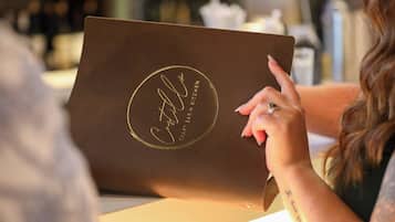 A person using a laptop with a logo on the lid.