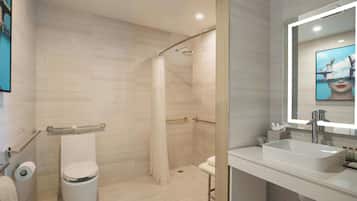 A modern bathroom with a shower, toilet, and sink.