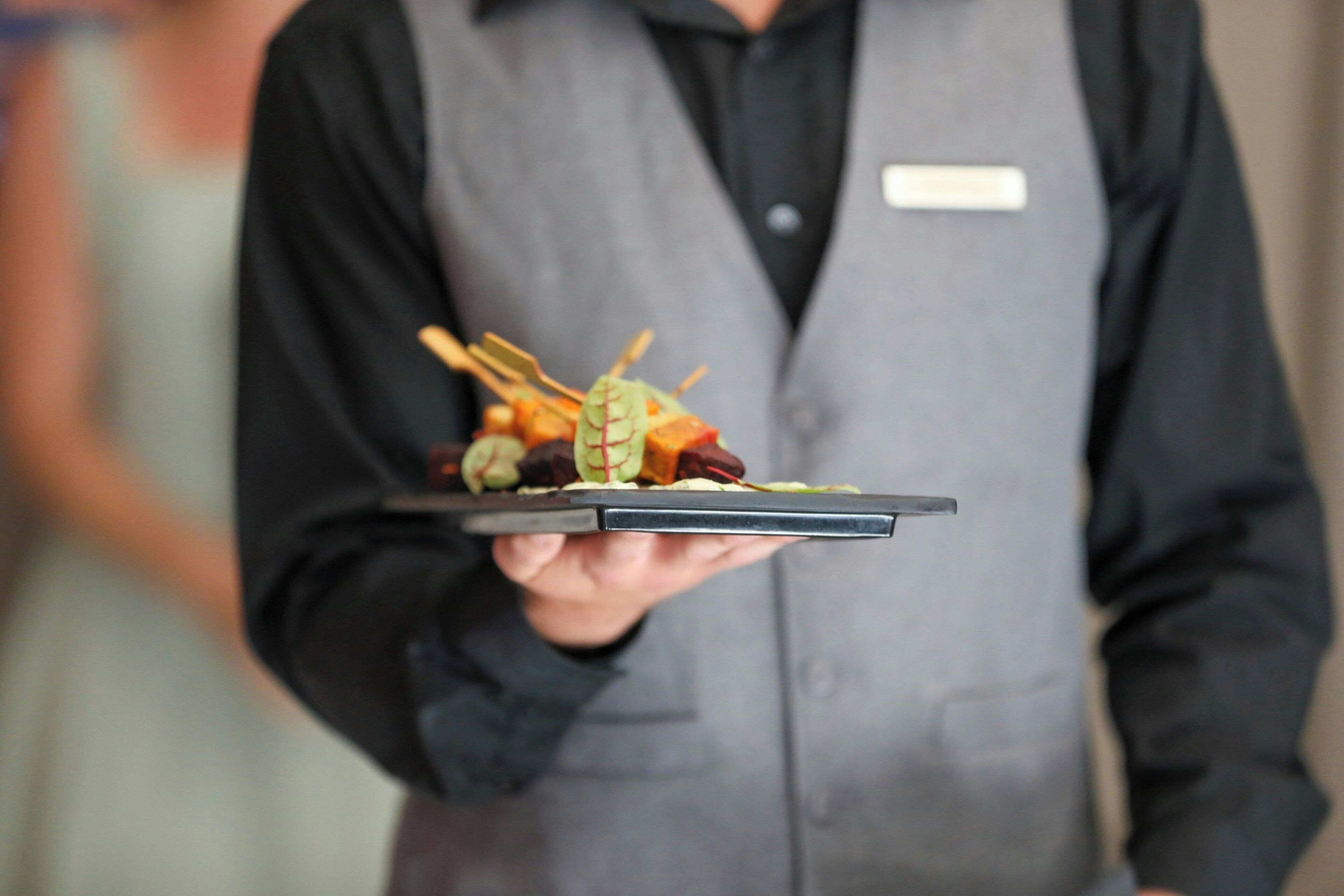 A person holding a tray with food items.