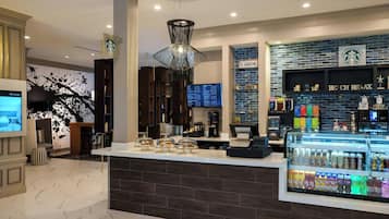 A modern Starbucks with a digital menu board, a coffee machine, and a variety of beverages.