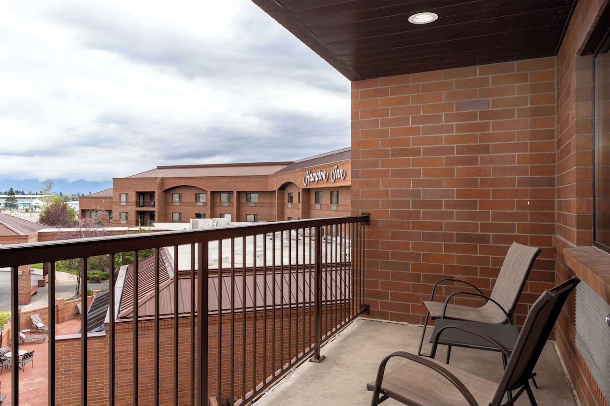A hotel balcony with a view of the building and a clear sky.