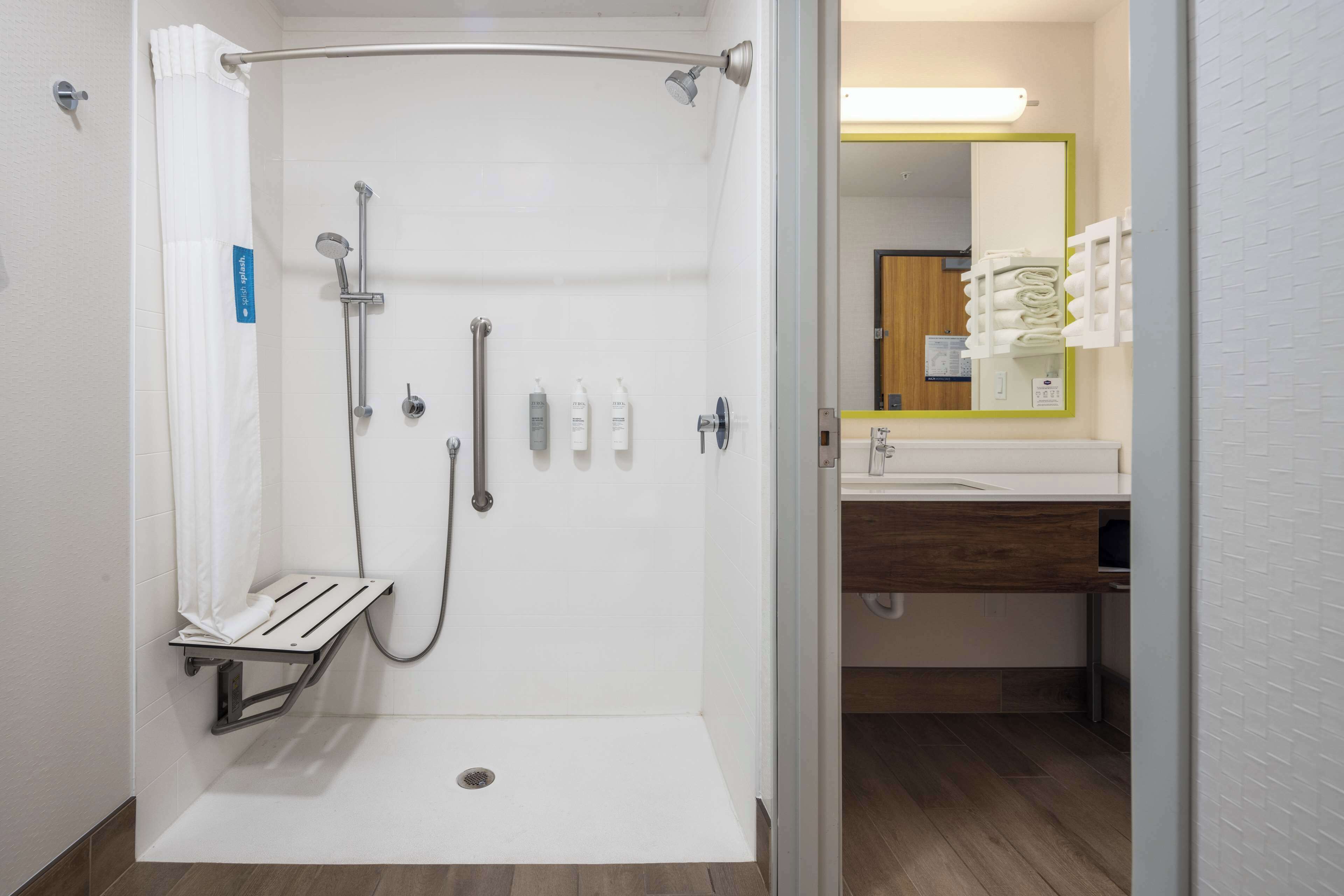 Et moderne badeværelse med bruser, toilet og vask.